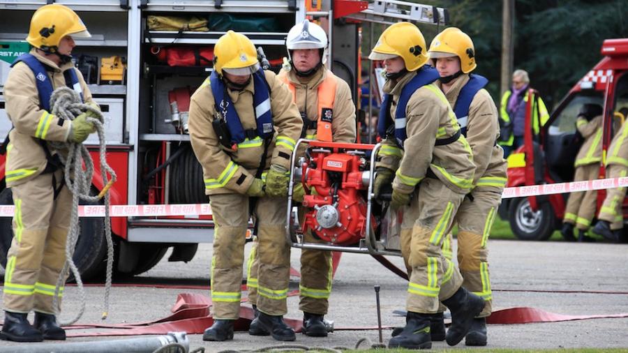 firefighters-carrying-water-pump