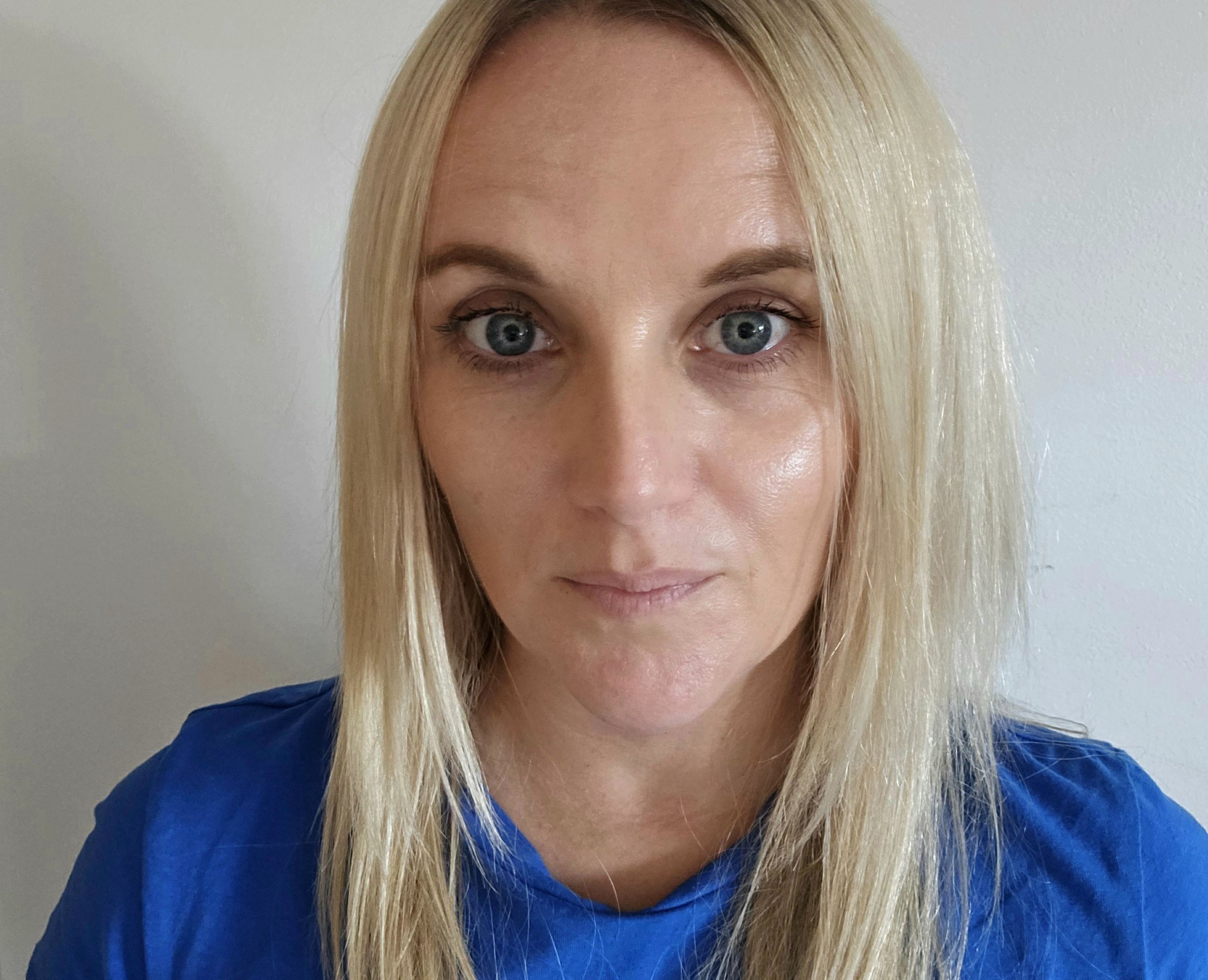 Woman with blond hair looks into camera