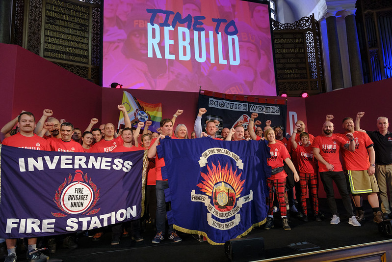 FBU members on stage at rally holding Inverness FBU banner 