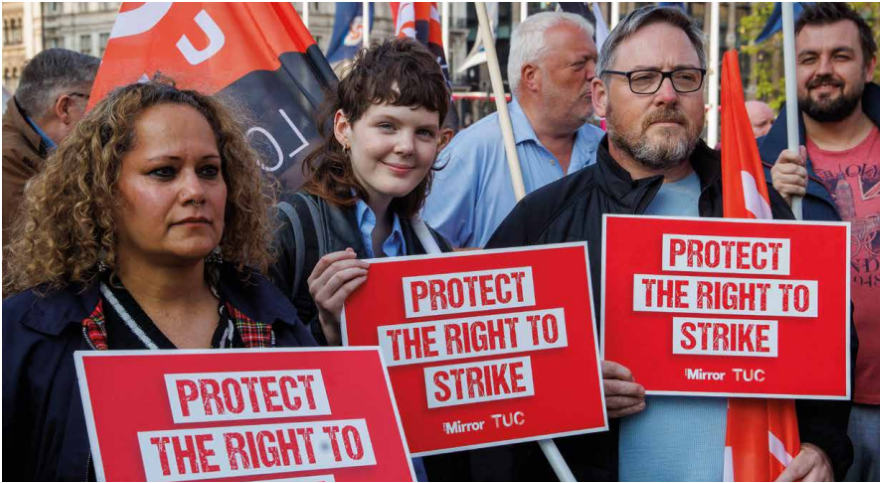 Three demonstrators hold protect the right to strike placards at TUC rally
