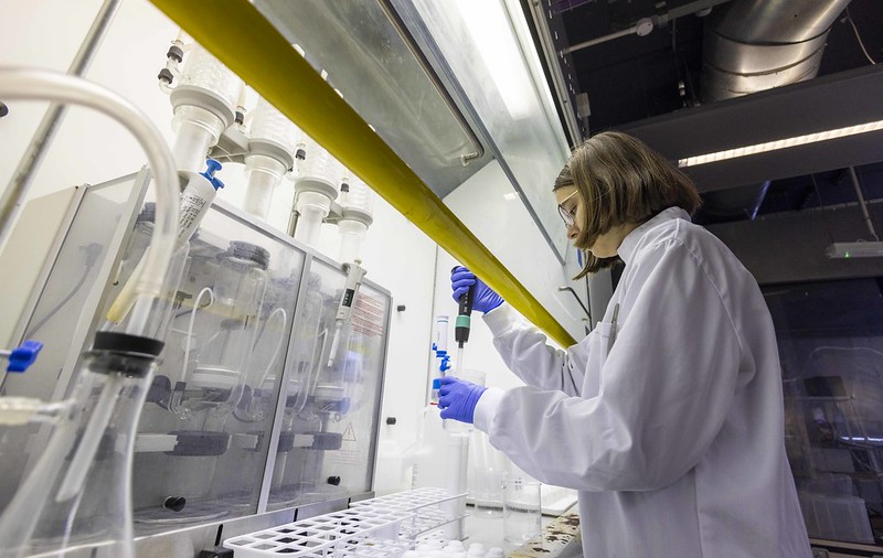 A scientist in lab coat tests samples in a lab
