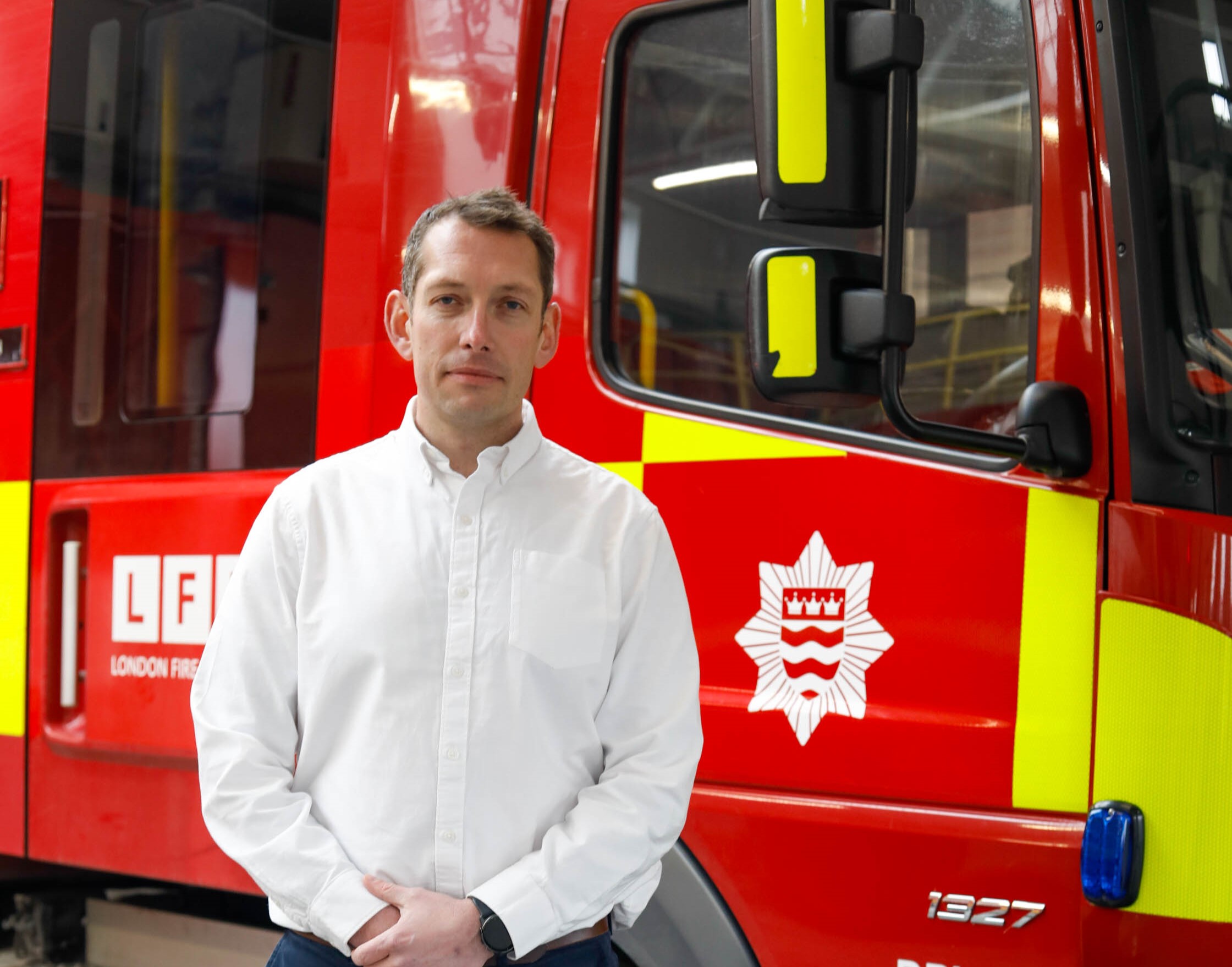 Steve Wright standing in front of a fire engine at Kingston fire station