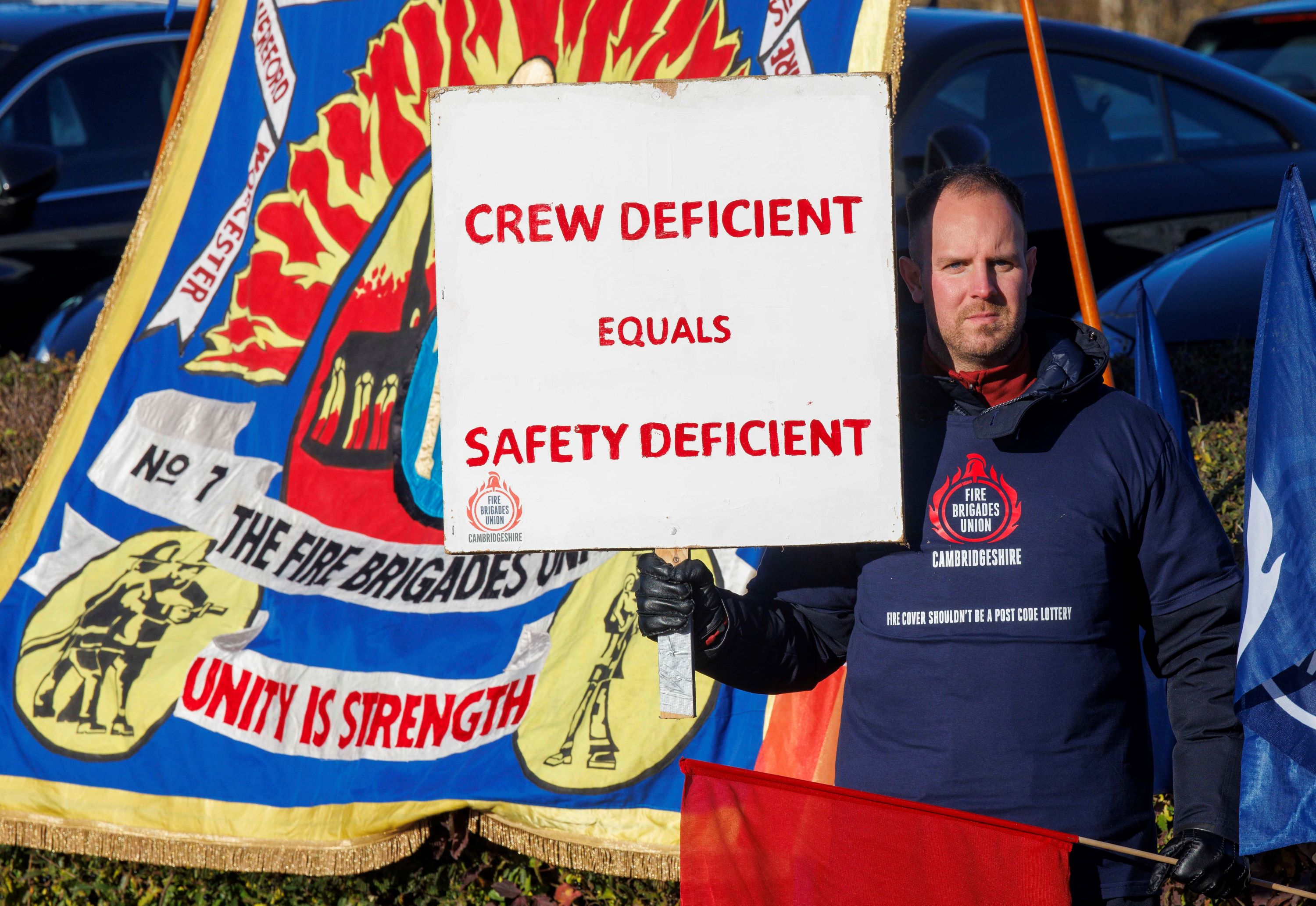 FBU member holds up a sign reading 'crew deficient equals safety deficient'