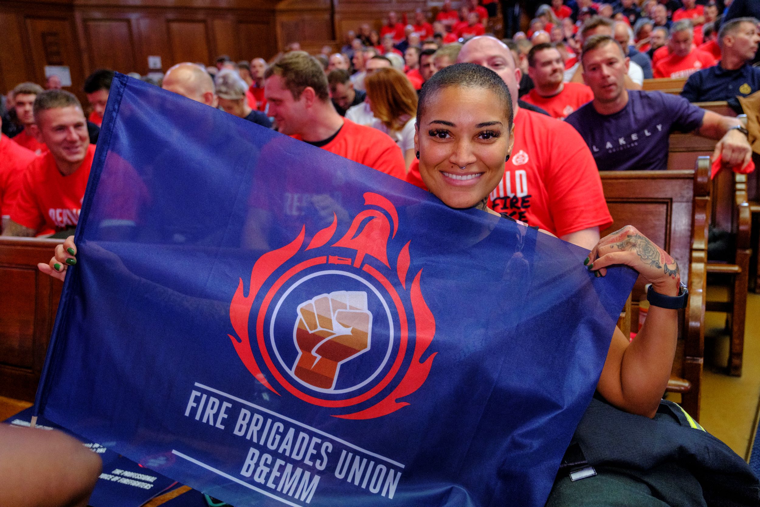 Kasey LeGall at a rally holding a BEMM section flag