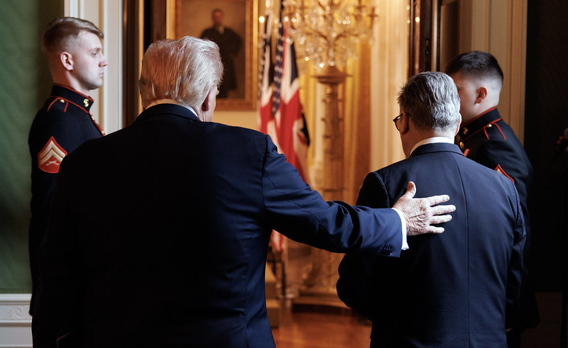 Donald Trump puts his hand on Keir Starmer's back as they face away from the camera