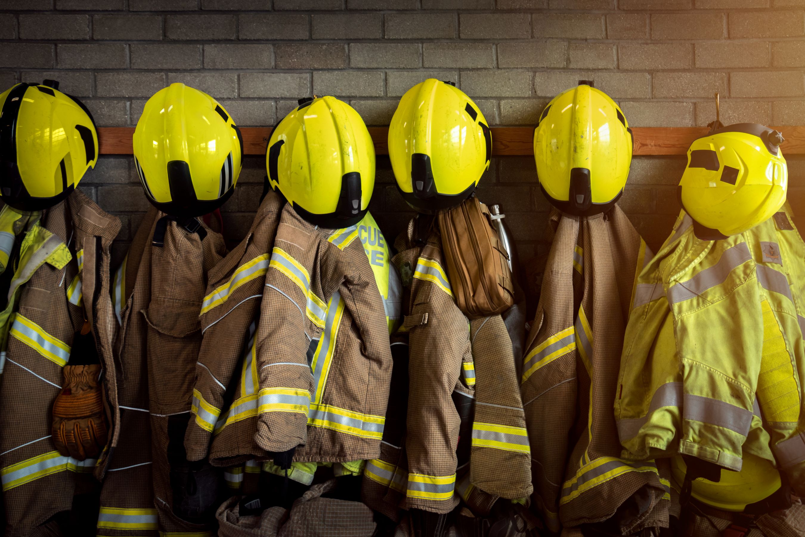 Fire kits handing up in a row with helmets on pegs