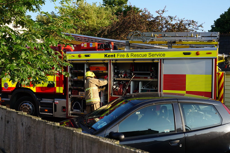 A fire engine being attended by a firefighter in Kent - by aldisley