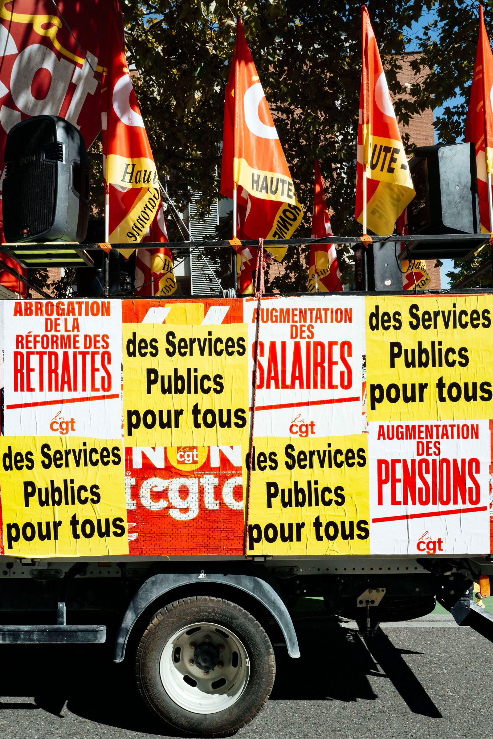 A float covered in posters in French at a strike rally