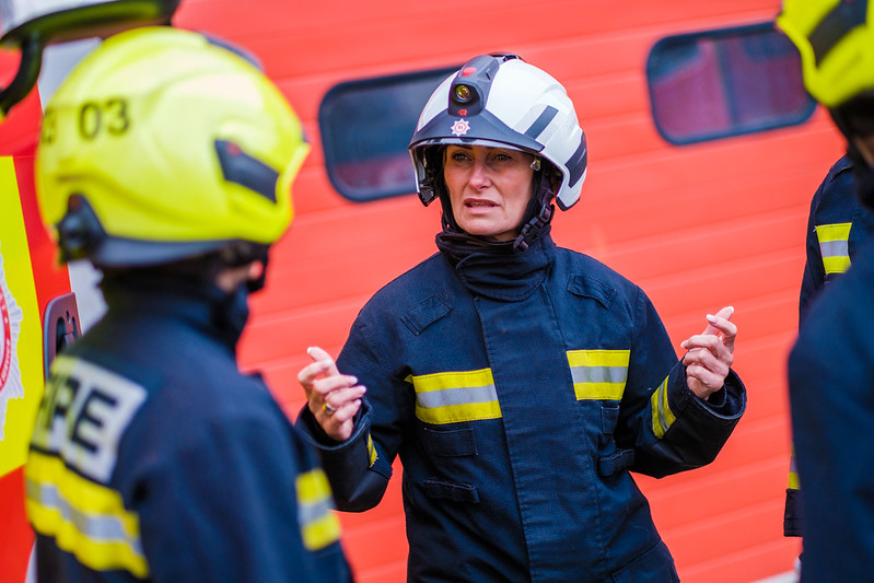 A firefighter talks to fellow women firefighters