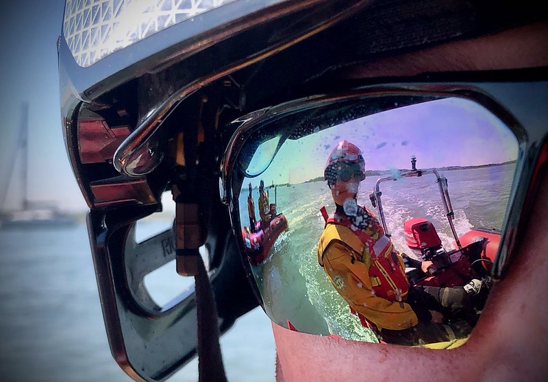 Firefighter wearing water goggles with rescue boat refected