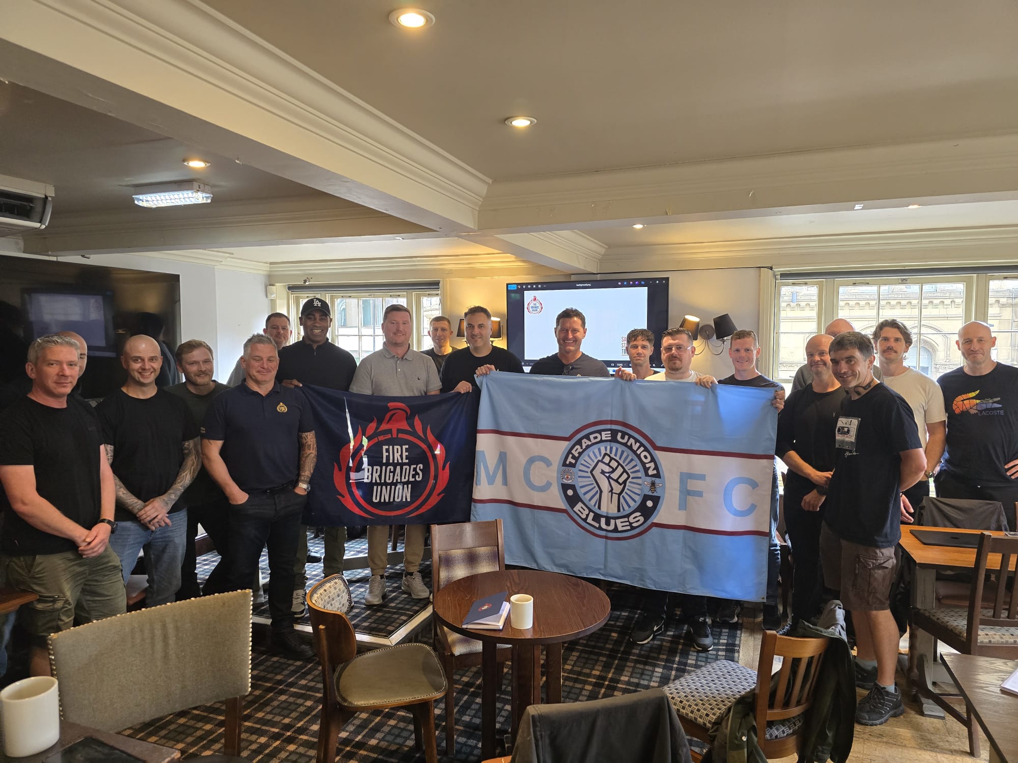 Members with a Trades Union Blues banner at an FBU meeting