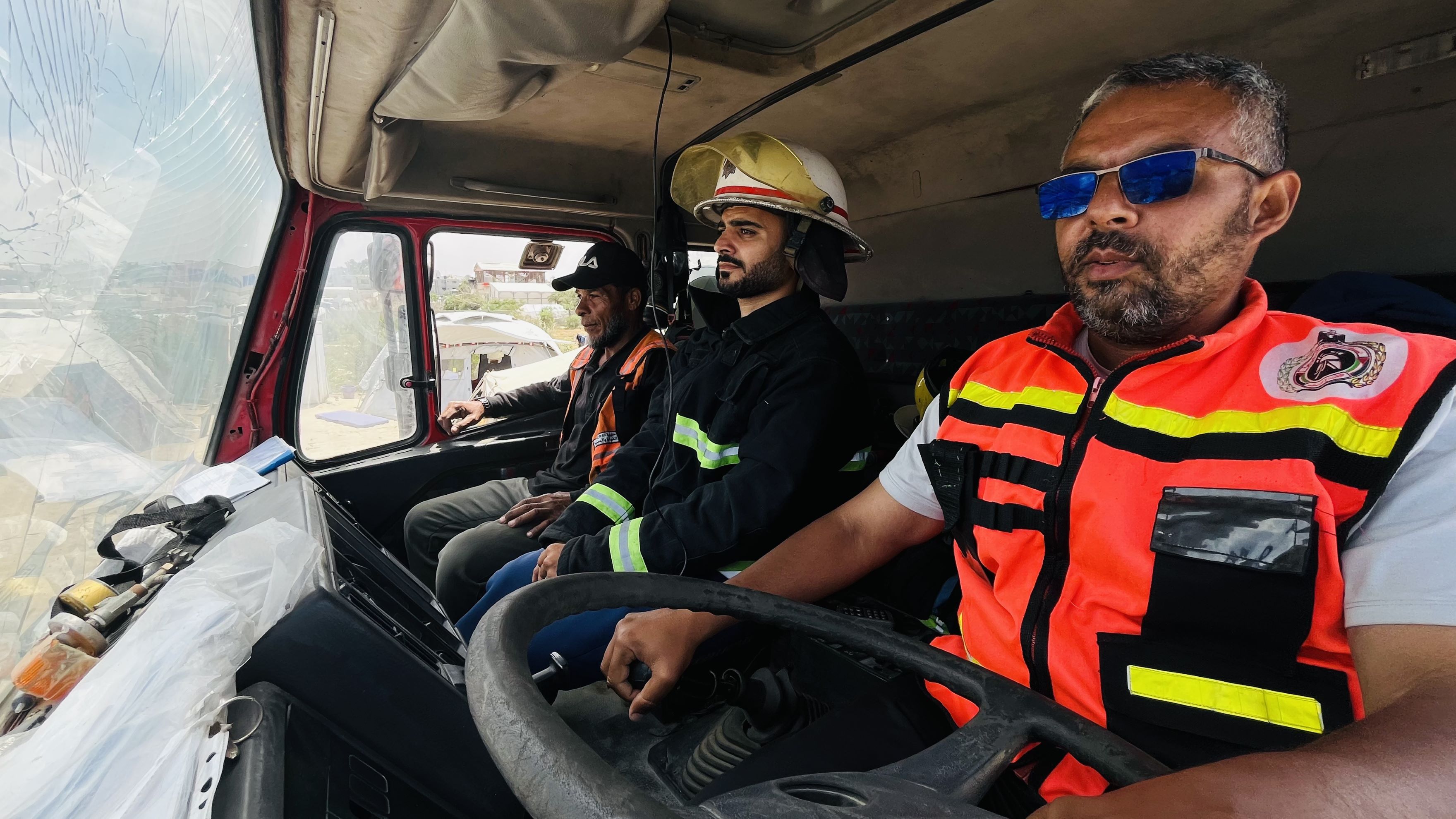 Two firefighter driving a fire appliance with a cracked windscreen