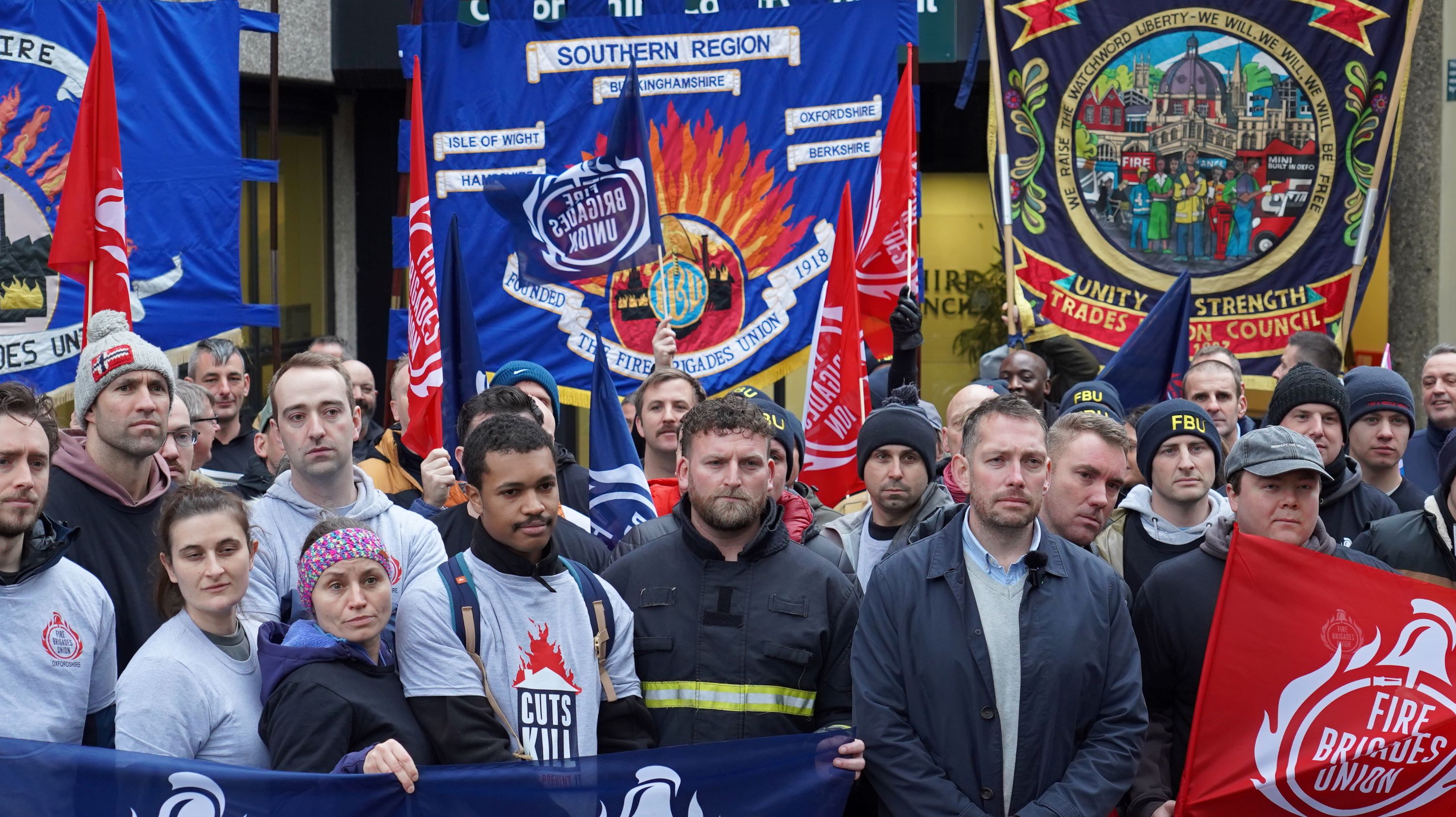 A crowd of firefighters with banners outside Oxfordshire county hall