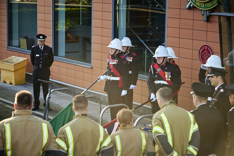 Assorted present and former firefighters at the unveiling, standing in formation 