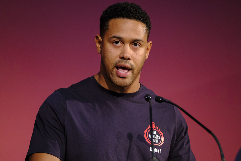 Dave Pitt speaks into a microphone wearing an FBU t shirt
