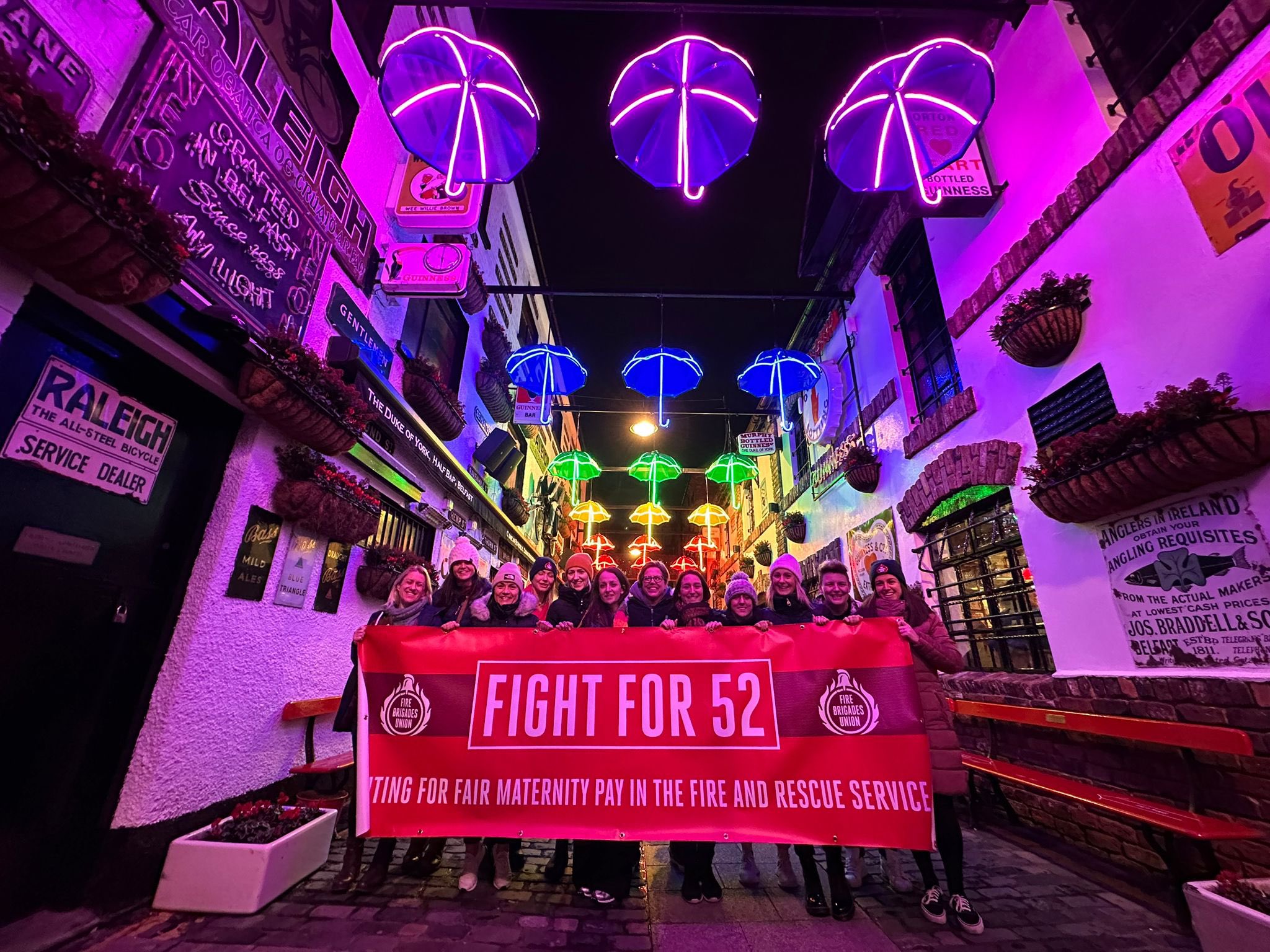 Women firefighters holding Fight for 52 banner in Belfast