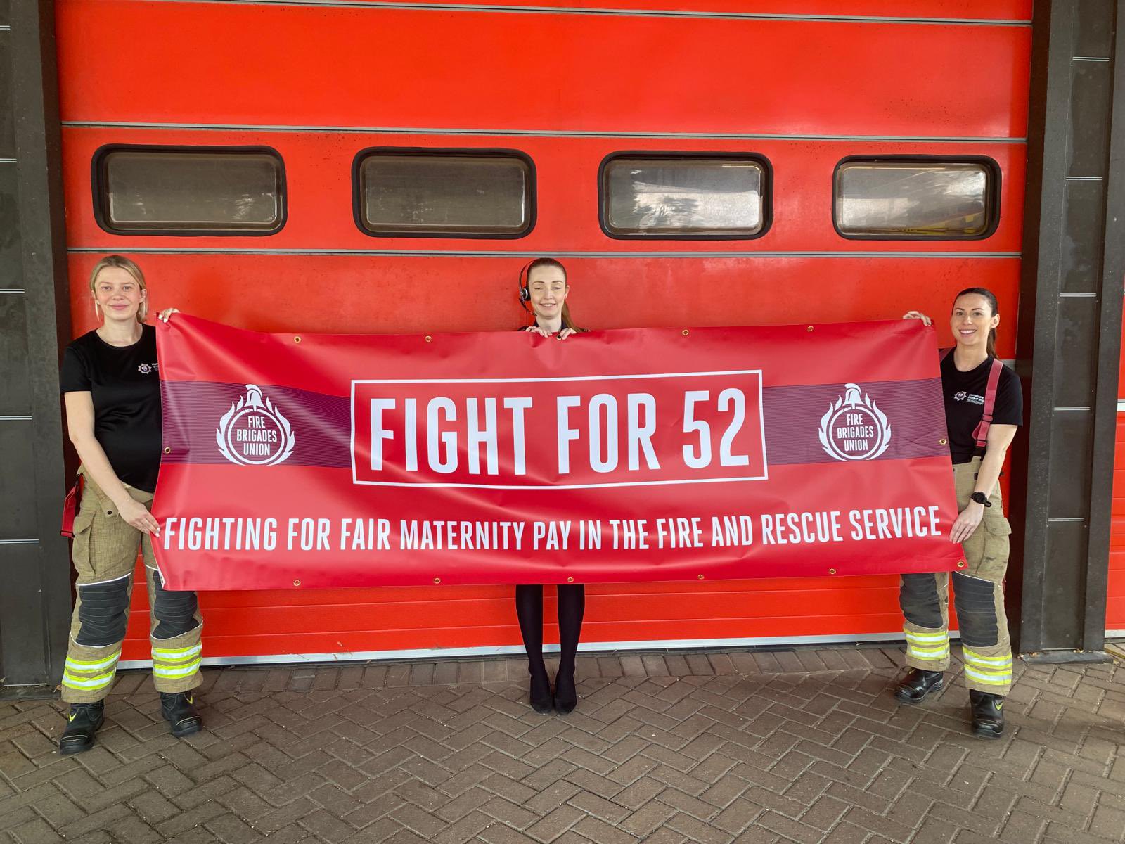 Women firefighters and fire control staff holding Fight for 52 banner