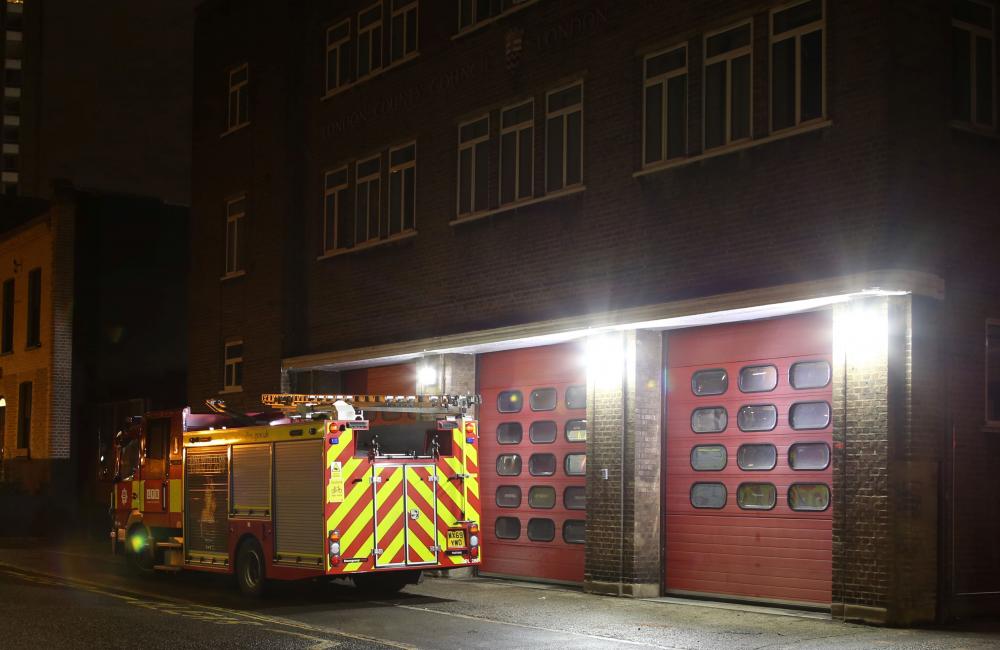 Fire station with fire appliance outside at night