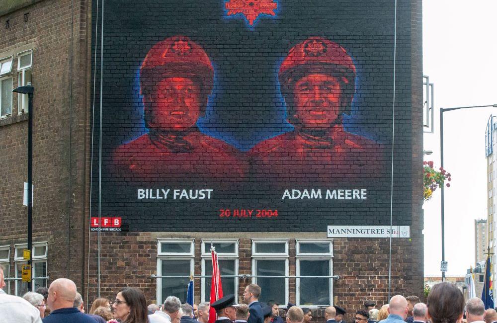 Mural painted on a brick wall in London depicting firefighters Adam Meere and Billy Faust