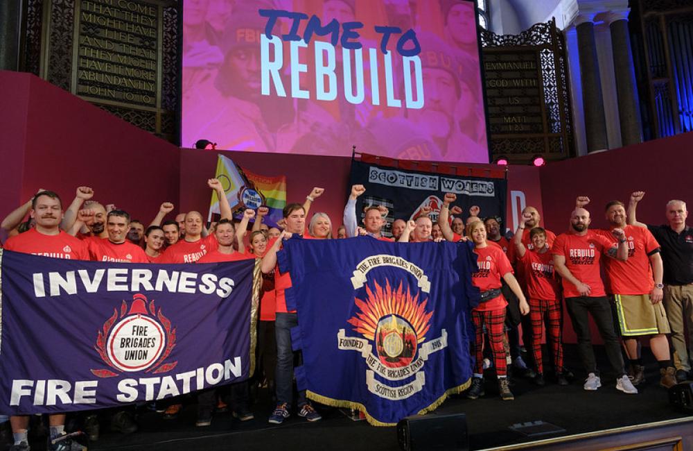 FBU members on stage at rally holding Inverness FBU banner 