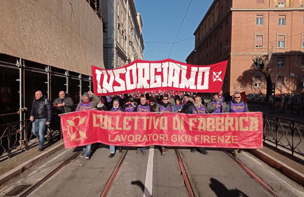 Workers from the GKN factory march with a banner reading "rise up" in Italian