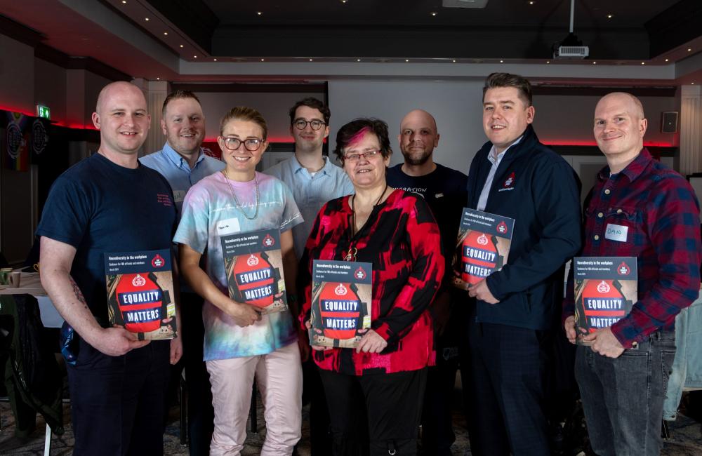 A group of FBU members hold up the FBU neurodiversity in the workplace guidance