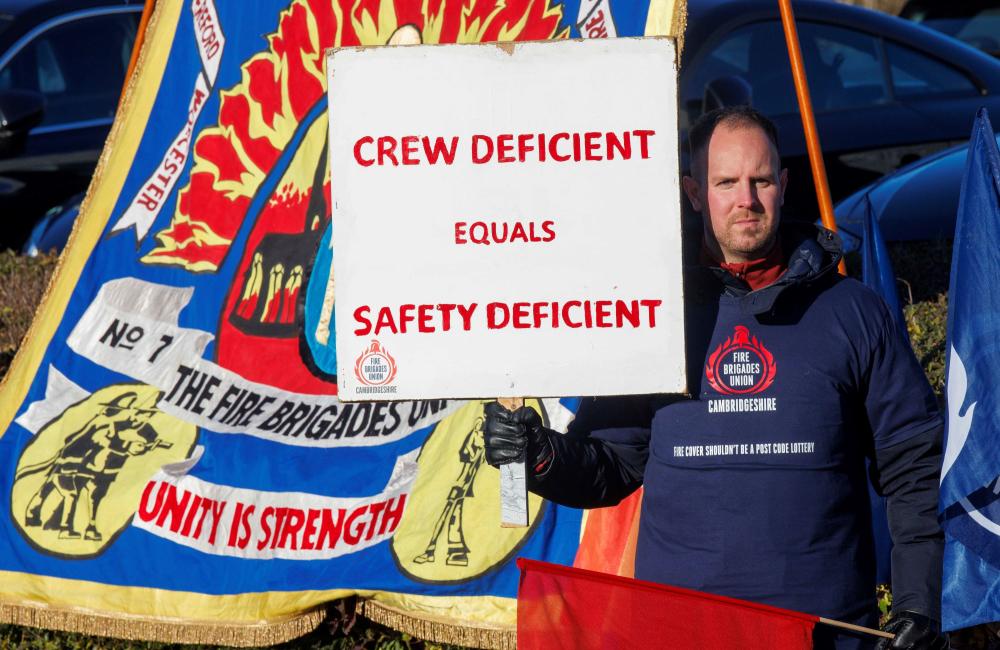 FBU member holds up a sign reading 'crew deficient equals safety deficient'