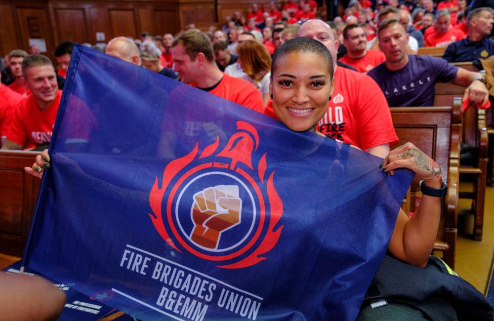 Kasey LeGall at a rally holding a BEMM section flag