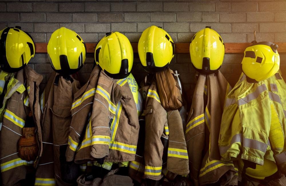 Fire kits handing up in a row with helmets on pegs