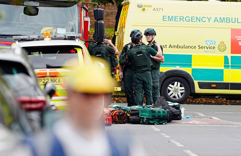Paramedics talking in front of ambulance in the road 
