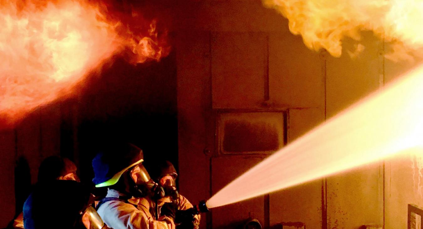Firefighters hose water on building blaze fire night