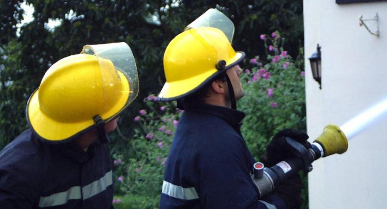 two-firefighters-hosing-house
