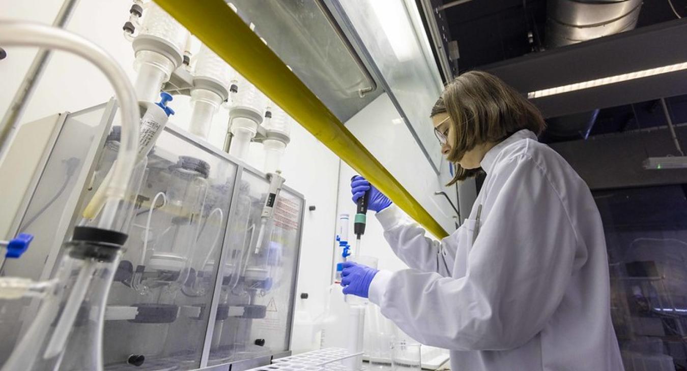 A scientist in lab coat tests samples in a lab