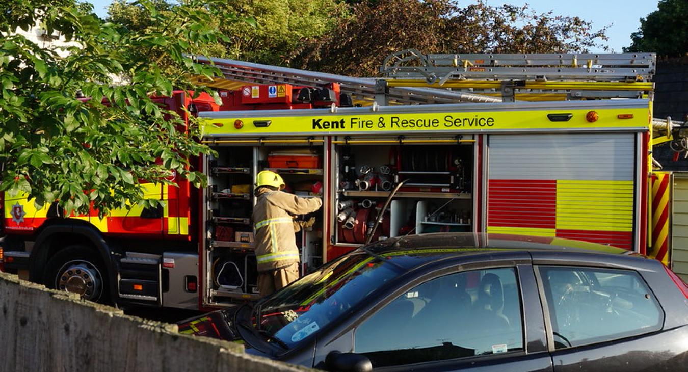 A fire engine being attended by a firefighter in Kent - by aldisley