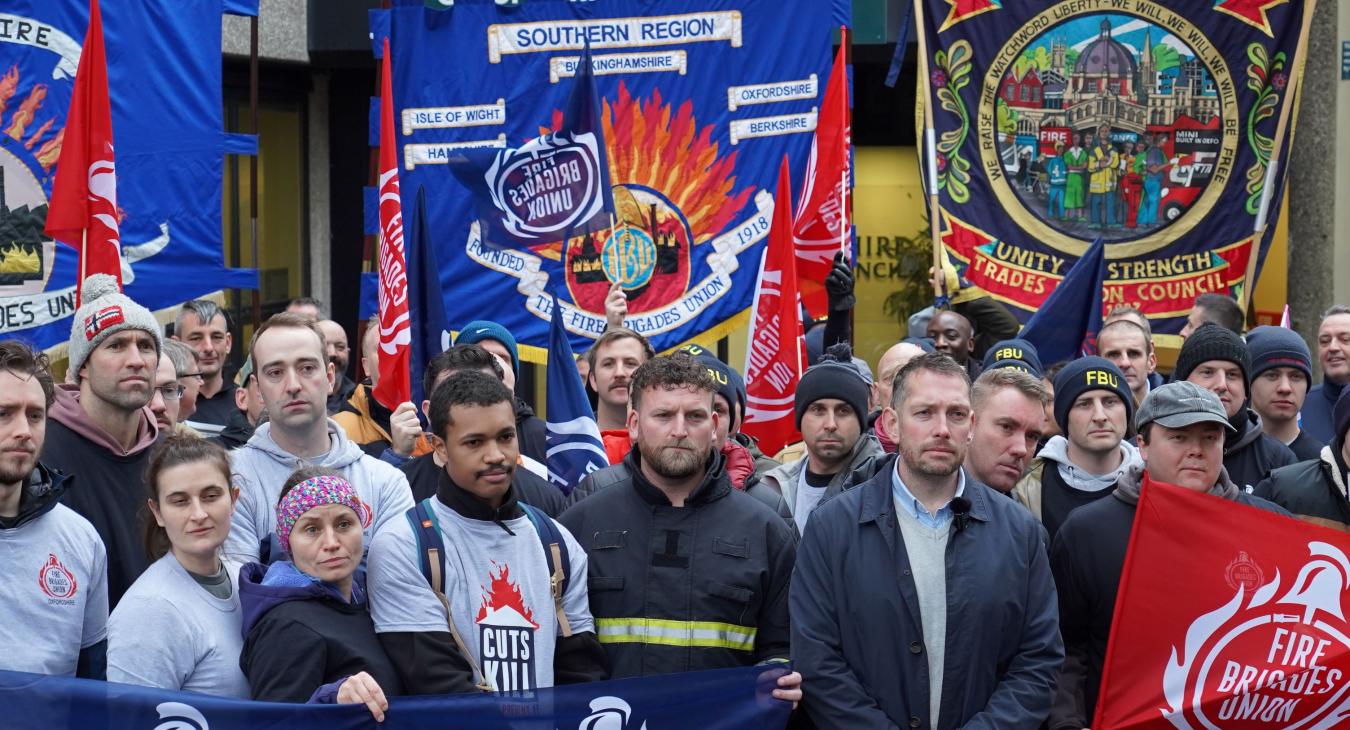 A crowd of firefighters with banners outside Oxfordshire county hall