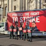 Five workers, including a firefighter, stand in front of a mobile billboard. The mobile billboard reads: protect the right to strike. The image is from the TUC day of action on February 1st 2023