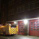 Fire station with fire appliance outside at night
