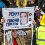 Firefighter holding sign that reads 'Penny Mordaunt penny pincher'