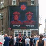Mural painted on a brick wall in London depicting firefighters Adam Meere and Billy Faust