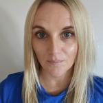 Woman with blond hair looks into camera