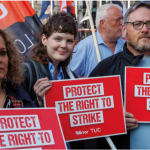 Three demonstrators hold protect the right to strike placards at TUC rally