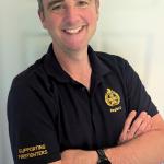 Matthew Black smiling at camera wearing FBU polo shirt