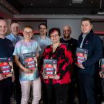 A group of FBU members hold up the FBU neurodiversity in the workplace guidance