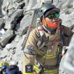 Firefighter in kit climbing a mountain
