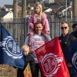 FBU member holding FBU flag with a child on his shoulders