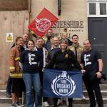 A group of FBU members hold flags outside Gloucestershire county council building