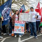 Firefighters gathered at a rally holding a sign reading 'family matters stop the attacks'