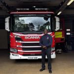 Dwight Williams standing next to a fire engine