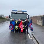 Three FBU members with flags stand in front of the donated fire engine
