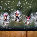 Firefighters jump into water from an aerial view